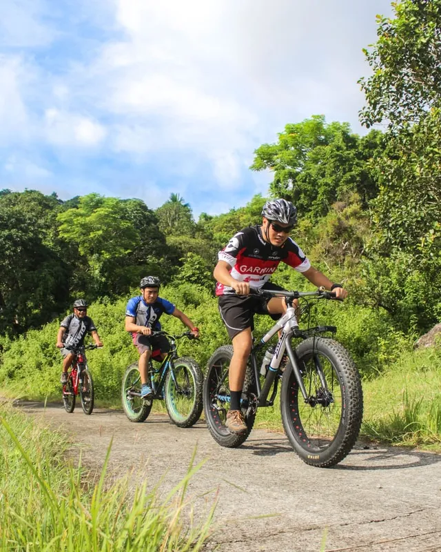 An adult mountain biker riding a trail bike outdoors